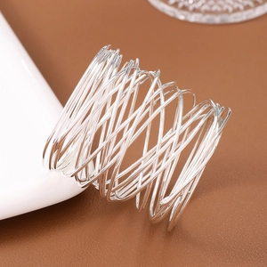 Detail of silver plated multi-layer wire wrapped napkin ring on luxury table setting
