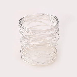 Macro shot of silver metal wire-wrapped napkin ring with modern industrial hollow design