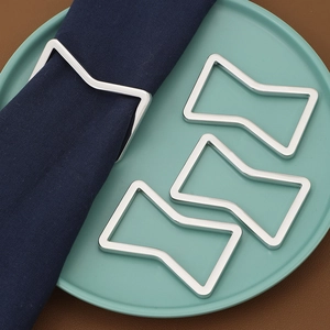 Set of 4 silver geometric metal napkin rings with a modern bow design for table decor