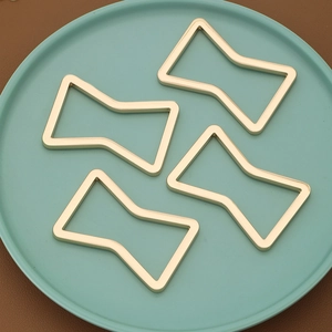 Macro shot of geometric gold hollow napkin rings arranged on a round ceramic tray