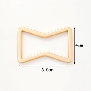 Detail showing dimensions of gold bow-shaped metal napkin ring with 6.5cm length