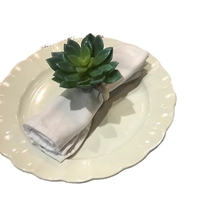 Succulent napkin ring with lifelike green petals on a cream base for table setting