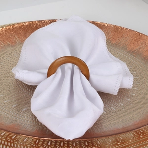 Rond de serviette en rotin tressé à la main sur une serviette en dentelle blanche