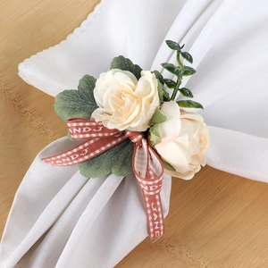 Beige fabric rose napkin ring with red plaid bow for elegant dining table decoration