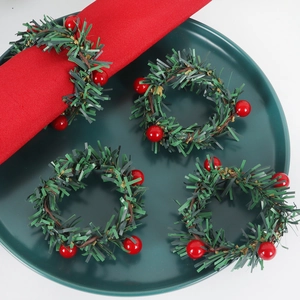 Détail de ronds de serviette de Noël faits main avec baies rouges et épines de pin