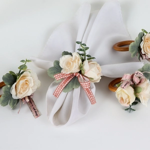 Close-up of fabric rose napkin rings with wooden loop and decorative ribbon details