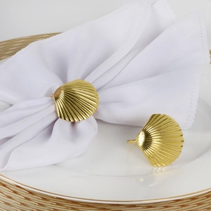 Detailed close-up of a golden scallop shell napkin ring with fine textured metal finish