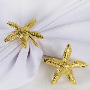 Detail view of golden starfish napkin rings with textured metallic finish and back loop