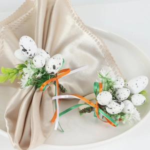Detail of Easter egg napkin ring with speckled egg, green leaves, and colorful ribbons
