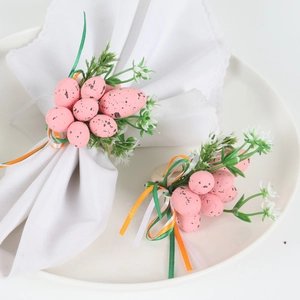 Easter napkin ring with pink speckled eggs, green foliage, and colorful ribbons on white cloth