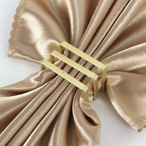 Elegante portatovagliolo dorato a forma di D con design a tre barre su raso champagne