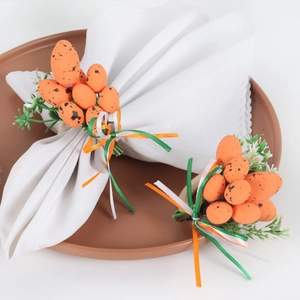 Detail of Easter napkin rings with orange speckled eggs and festive green ribbons