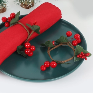 Christmas berry napkin ring set with red fruit and green leaves on dark ceramic plate
