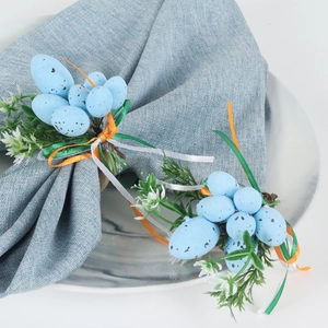 Easter napkin ring featuring light blue speckled eggs with green leaves and ribbons