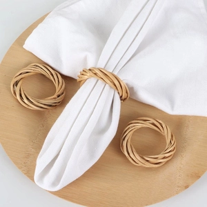 Handwoven natural rattan napkin rings set on a wooden plate for rustic table decor