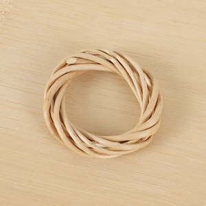 Detailed view of handmade woven rattan napkin ring with natural rustic wood texture