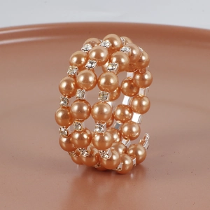 Gros plan du rond de serviette en perles champagne avec des strass étincelants