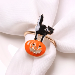 Halloween napkin ring featuring a black cat and orange pumpkin on a gold metal band