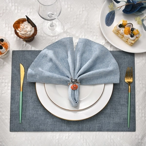 Halloween napkin ring set featuring black cat and pumpkin design on blue linen napkin