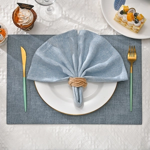 Handwoven hemp rope napkin ring on blue linen napkin with elegant table setting