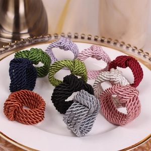 Detailed close-up of colorful woven rope napkin rings displayed on a white ceramic plate