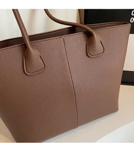 Detail of premium brown tote bag showing vertical stitching and pebbled leather texture