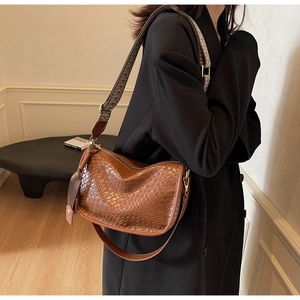 Détail du sac à bandoulière marron à texture tissée avec deux lanières chics