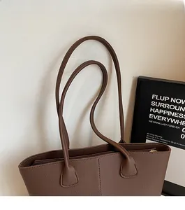 Detail of deep brown pebble leather tote bag featuring sturdy double shoulder straps