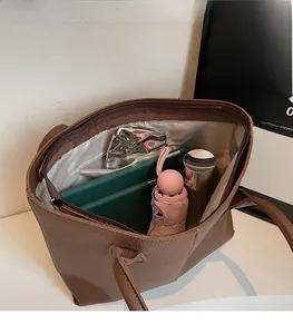 Interior view of large brown tote bag showing spacious storage for tablet and essentials