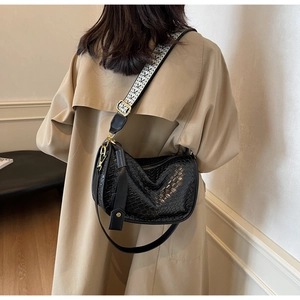 Sac en cuir PU tressé noir avec bandoulière jacquard et détails dorés porté par un modèle
