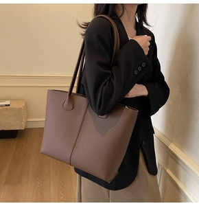 Detail view of brown lychee grain leather tote bag with elegant double stitching accents