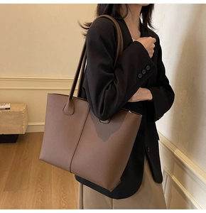 Detailed view of brown lychee texture tote bag featuring spacious design and leather grain
