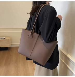 Detail showing the brown lychee grain leather texture and spacious tote bag shoulder strap