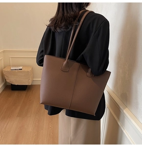 Deep brown pebble leather tote bag shown from side back view on model for daily commute