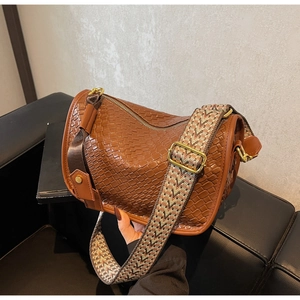 Détail du sac Boston marron tressé avec bandoulière tissée aux motifs géométriques