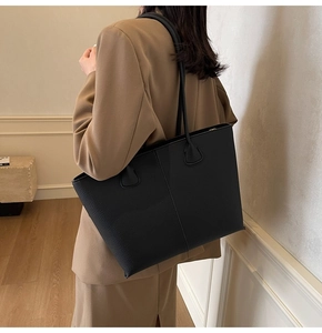 Detail of large black leather tote bag with lychee texture for office commuting