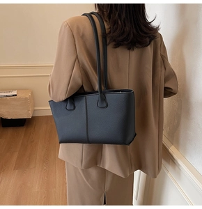 Detail shot of the black lychee pattern leather tote bag with long shoulder straps