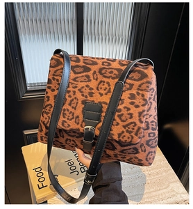 Dettaglio della borsa tote leopardata con tracolla in pelle nera e fibbia in metallo