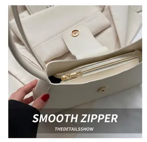 Detail of cream leather shoulder bag with gold magnetic buckle and smooth zipper closure