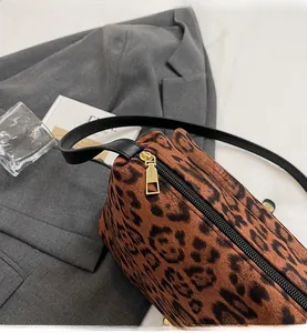 Dettaglio della cerniera dorata e del camoscio con stampa leopardata sulla borsa a tracolla