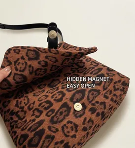 Dettaglio della chiusura magnetica dorata di una borsa a tracolla con stampa leopardata