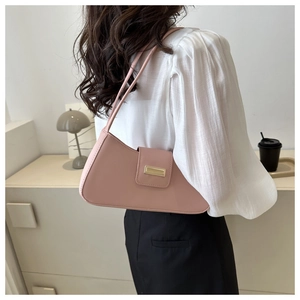 Detail of pink faux leather hobo bag with gold buckle worn on a model's shoulder