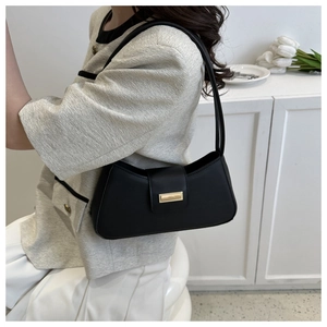 Detail showing a stylish black leather underarm bag with an elegant gold rectangular buckle
