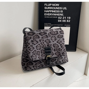 Dettaglio della borsa leopardata con patta in pelle nera e fibbia in metallo dorato