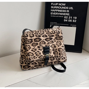 Dettaglio borsa a tracolla leopardata con cinturino in pelle nera e fibbia dorata