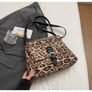 Dettaglio borsa a tracolla leopardata con fibbia dorata e cinturino in pelle nera