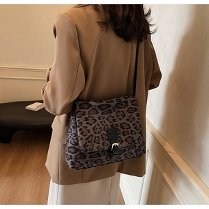 Dettaglio della borsa leopardata grigia con texture scamosciata e fibbia in metallo su modella