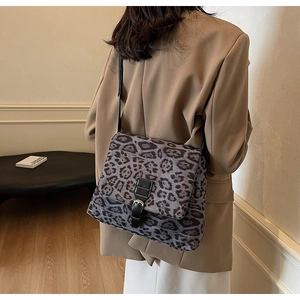 Dettaglio della borsa tote leopardata grigia con cinturino nero e fibbia su blazer
