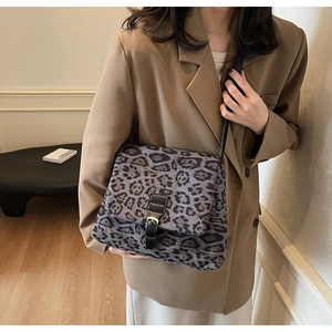 Dettaglio della borsa in peluche leopardata grigia con cinturino in pelle e fibbia