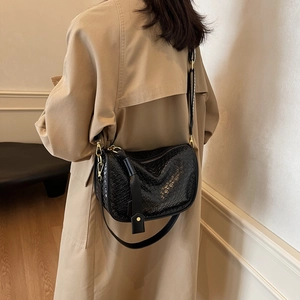 Sac bandoulière chic en noir tissé pour femme avec détails dorés et large sangle